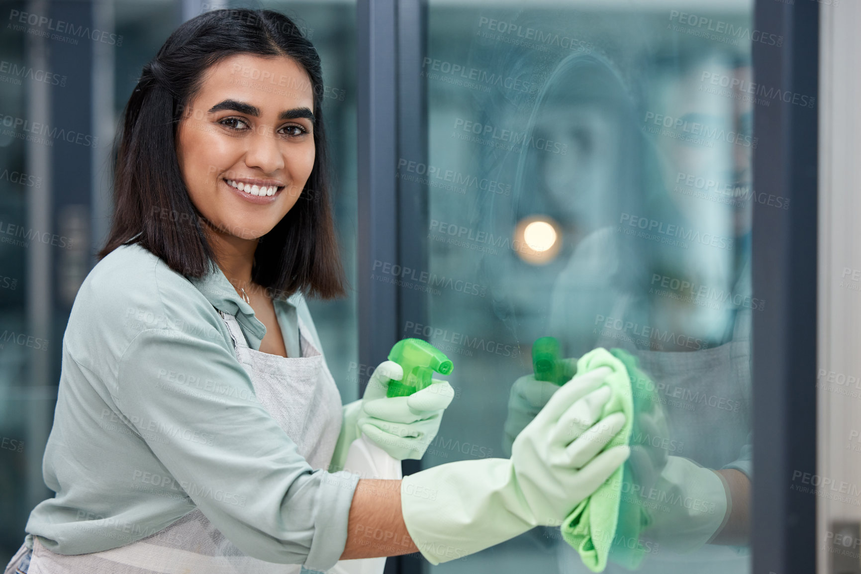 Buy stock photo Shot of a young woman cleaning her windows