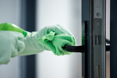 Buy stock photo Shot of a woman wiping down the handles on her door