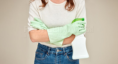 Buy stock photo Shot of an unrecognizable person standing with their arms crossed while holding a spray bottle against a white background