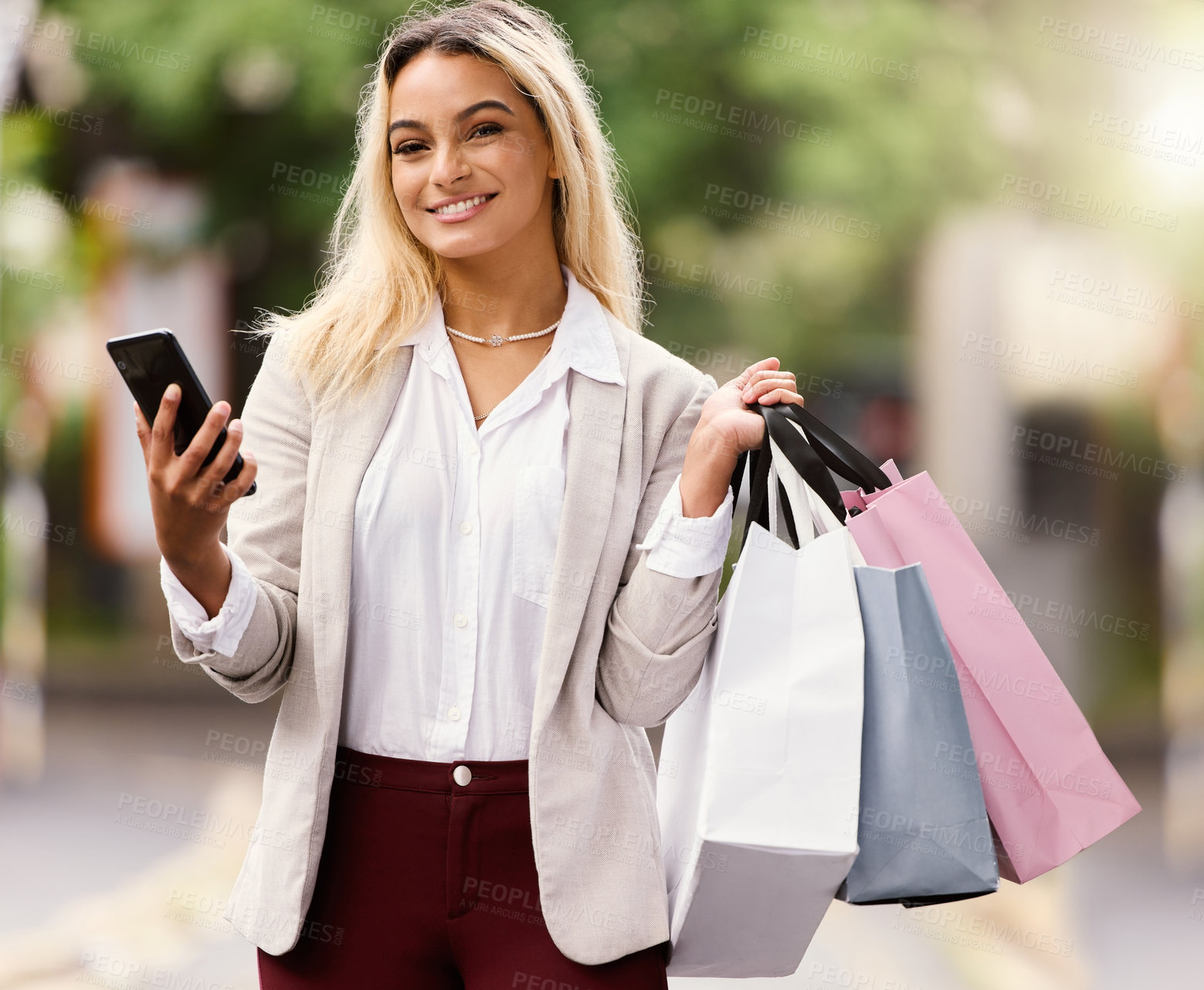 Buy stock photo Cropped portrait of an attractive young woman texting while out shopping in the city