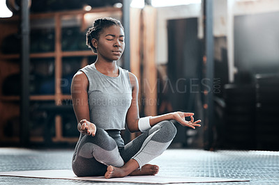 Buy stock photo Shot of a young woman doing some deep meditation at the gym