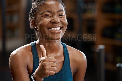 Buy stock photo Cropped portrait of an attractive and athletic young woman giving you thumbs up in the gym