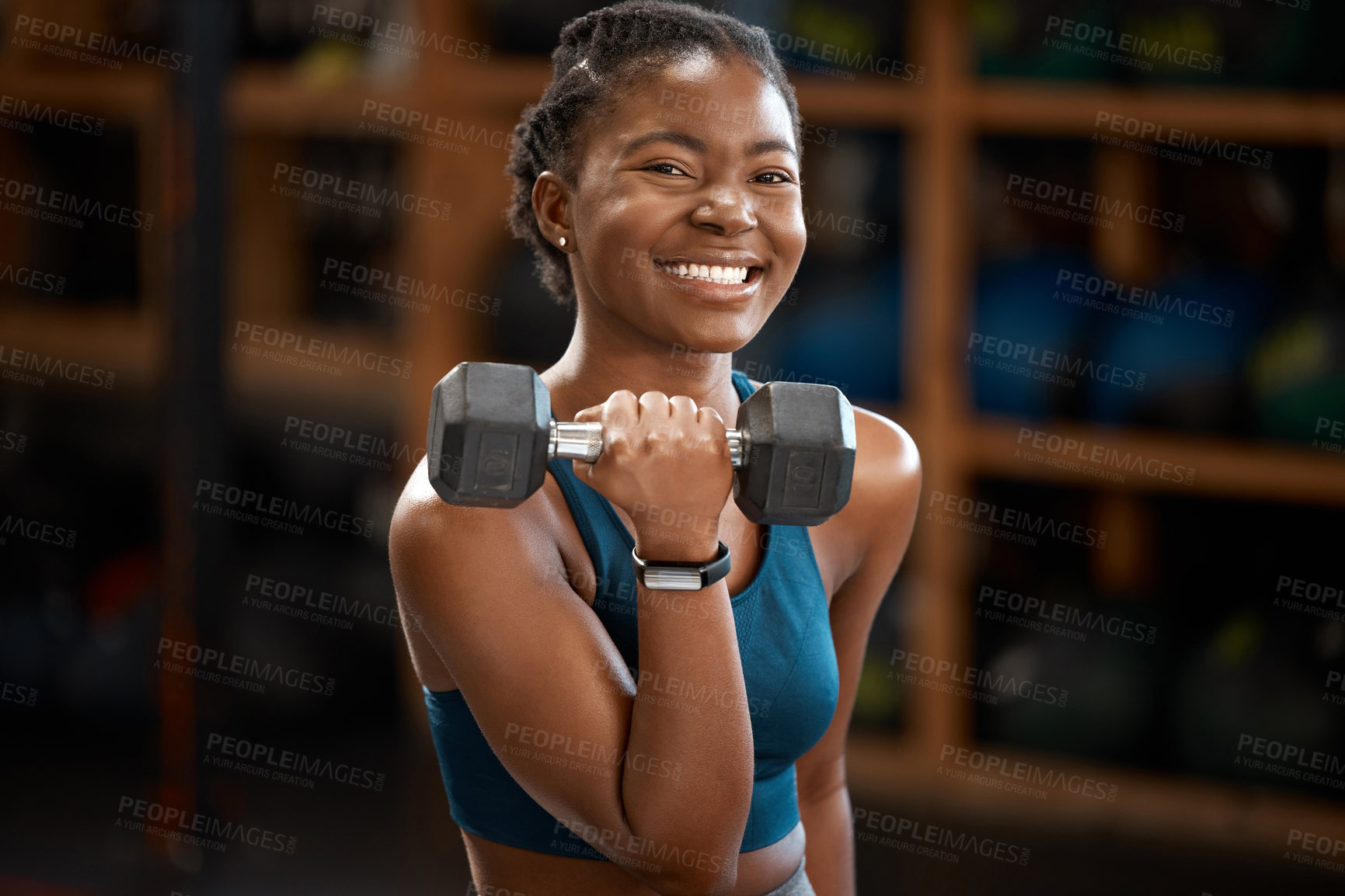 Buy stock photo Cropped portrait of an attractive and athletic young woman working out with a dumbbell in the gym