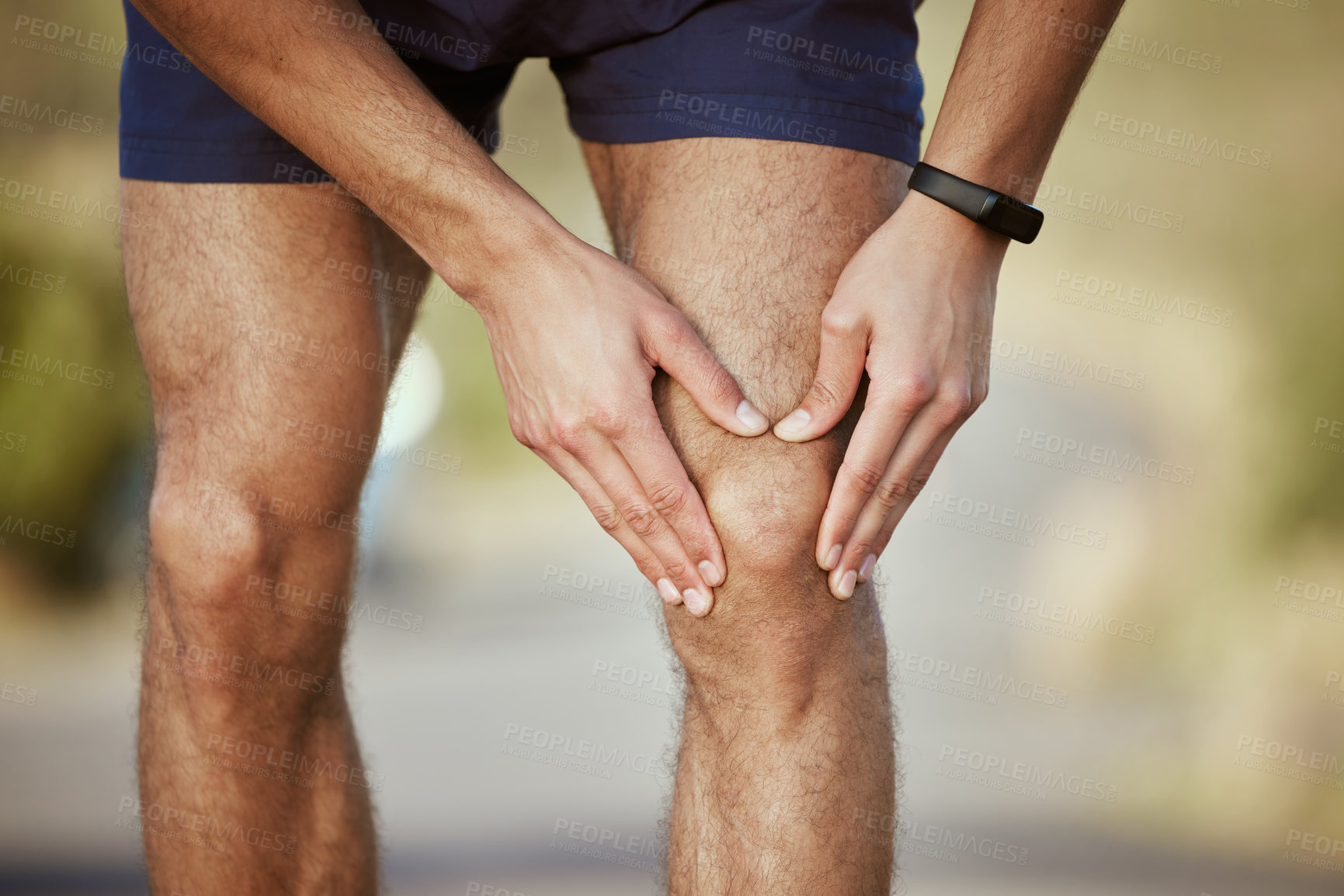 Buy stock photo Closeup shot of an unrecognisable man holding his knee in pain while exercising outdoors