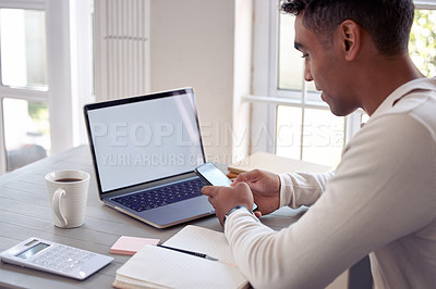 Buy stock photo Shot of a young male using his cellphone at home