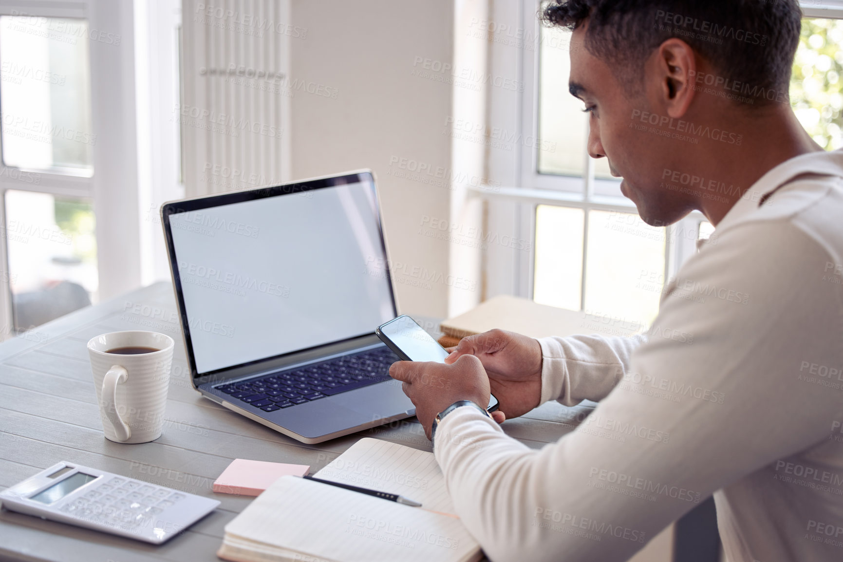 Buy stock photo Shot of a young male using his cellphone at home