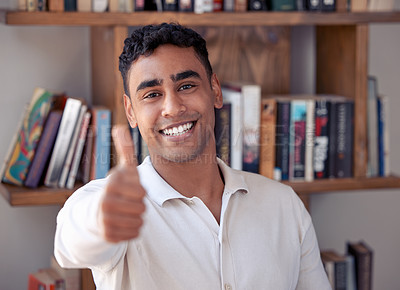 Buy stock photo Shot of a young man showing thumbs up at home