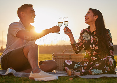 Buy stock photo Cheers, love and happy couple on a picnic together in nature on grass in summer for romance. Happiness, toast and young man and woman on outdoor sunset date with champagne to celebrate valentines day