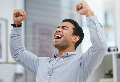 Buy stock photo Shot of a young businessman celebrating in his office