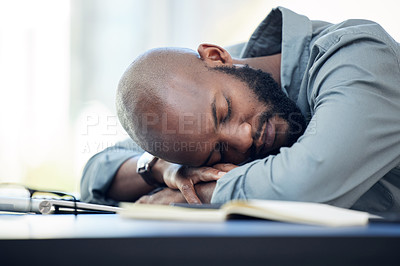 Buy stock photo Shot of a handsome young businessman sleeping on his desk in the office