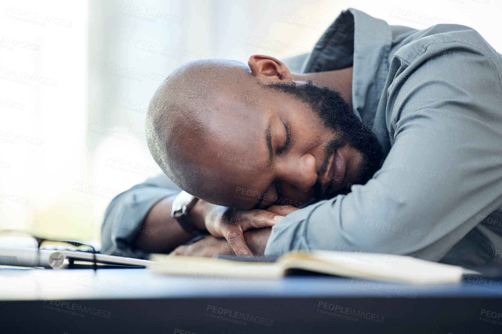 Buy stock photo Shot of a handsome young businessman sleeping on his desk in the office