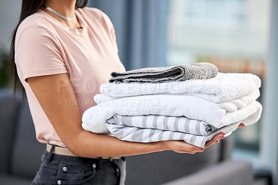 Buy stock photo Shot of a unrecognizable woman holding towels at home