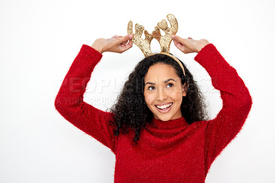 Buy stock photo Studio shot of a young woman wearing a reindeer antlers headband against a white background