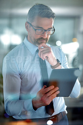 Buy stock photo Shot of a businessman using a digital tablet at the office