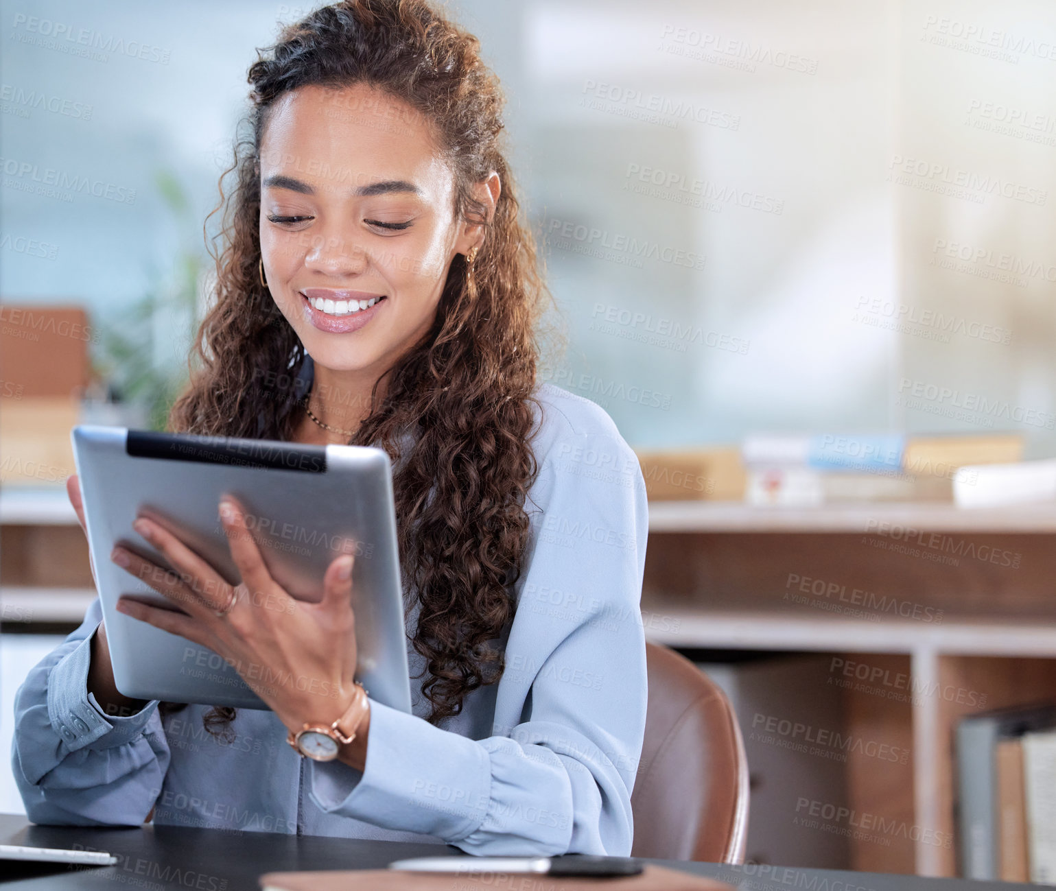 Buy stock photo Cropped shot of an attractive young businesswoman working on her tablet while sitting in the office