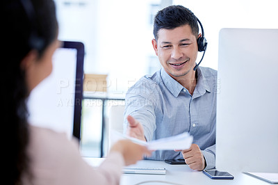 Buy stock photo Shot of a young call centre agent sitting and working with a colleague in the office