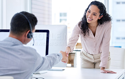 Buy stock photo Shot of a young call centre agent shaking her colleague's hand in the office during the day