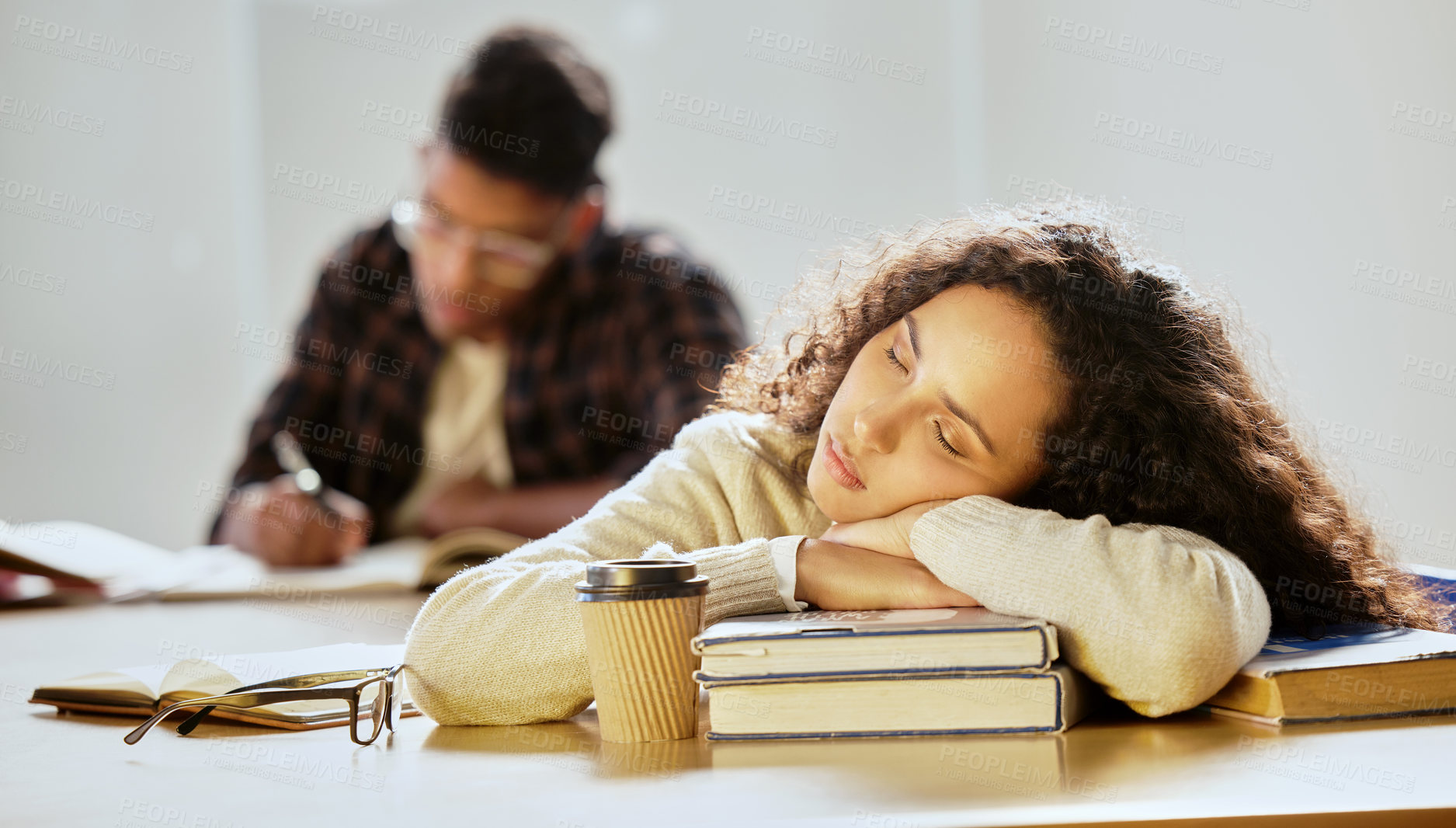 Buy stock photo Cropped shot of an attractive young female college student sleeping on her textbooks in class