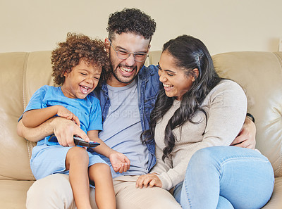 Buy stock photo Shot of a young family watching TV together