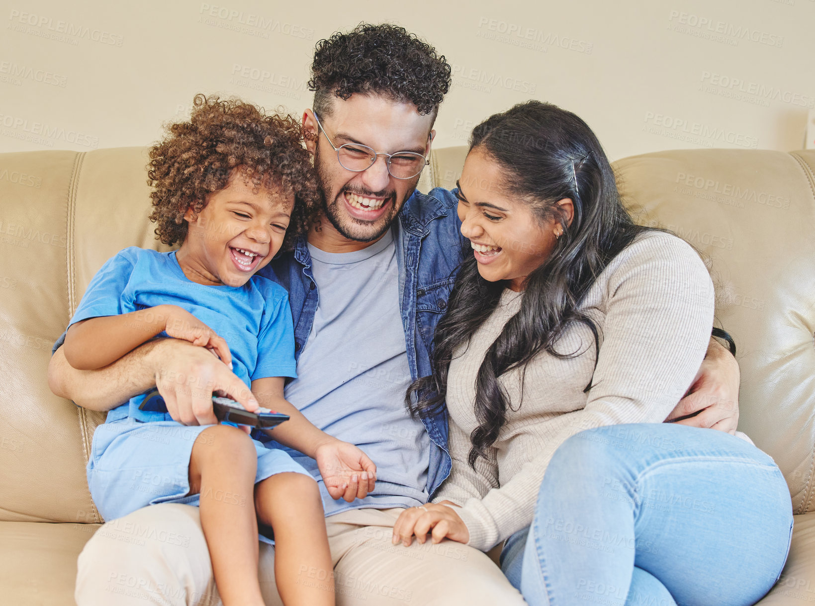 Buy stock photo Shot of a young family watching TV together