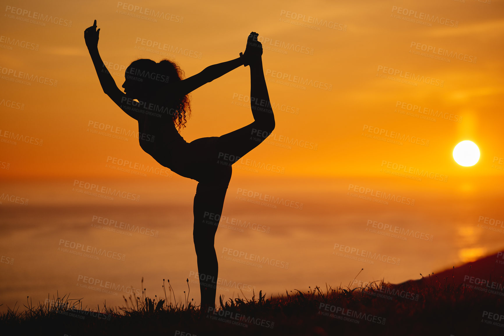 Buy stock photo Yoga, sunset and woman with silhouette and leg stretching and flexible pose in air in nature. Outdoor, healthy balance and wellness by the sea with health and dusk with body on a hill with zen