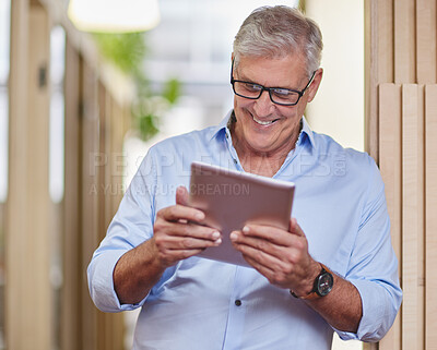 Buy stock photo Cropped shot of a handsome mature businessman using a table while standing in the hallway in his office