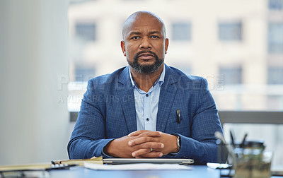 Buy stock photo Shot of a handsome mature businessman sitting alone in his office with his hands clasped