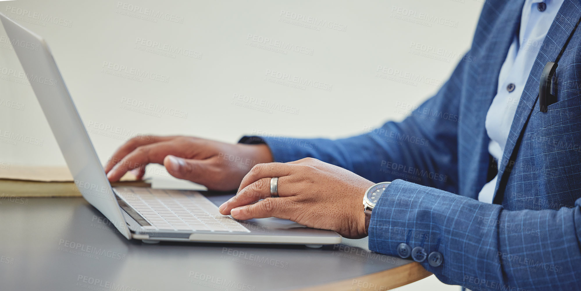 Buy stock photo Cropped shot of an unrecognizable businessman sitting alone in his office and using his laptop