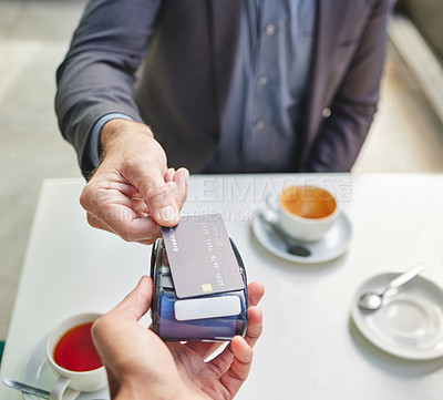 Buy stock photo Shot of a businessman using his debit card to pay for coffee