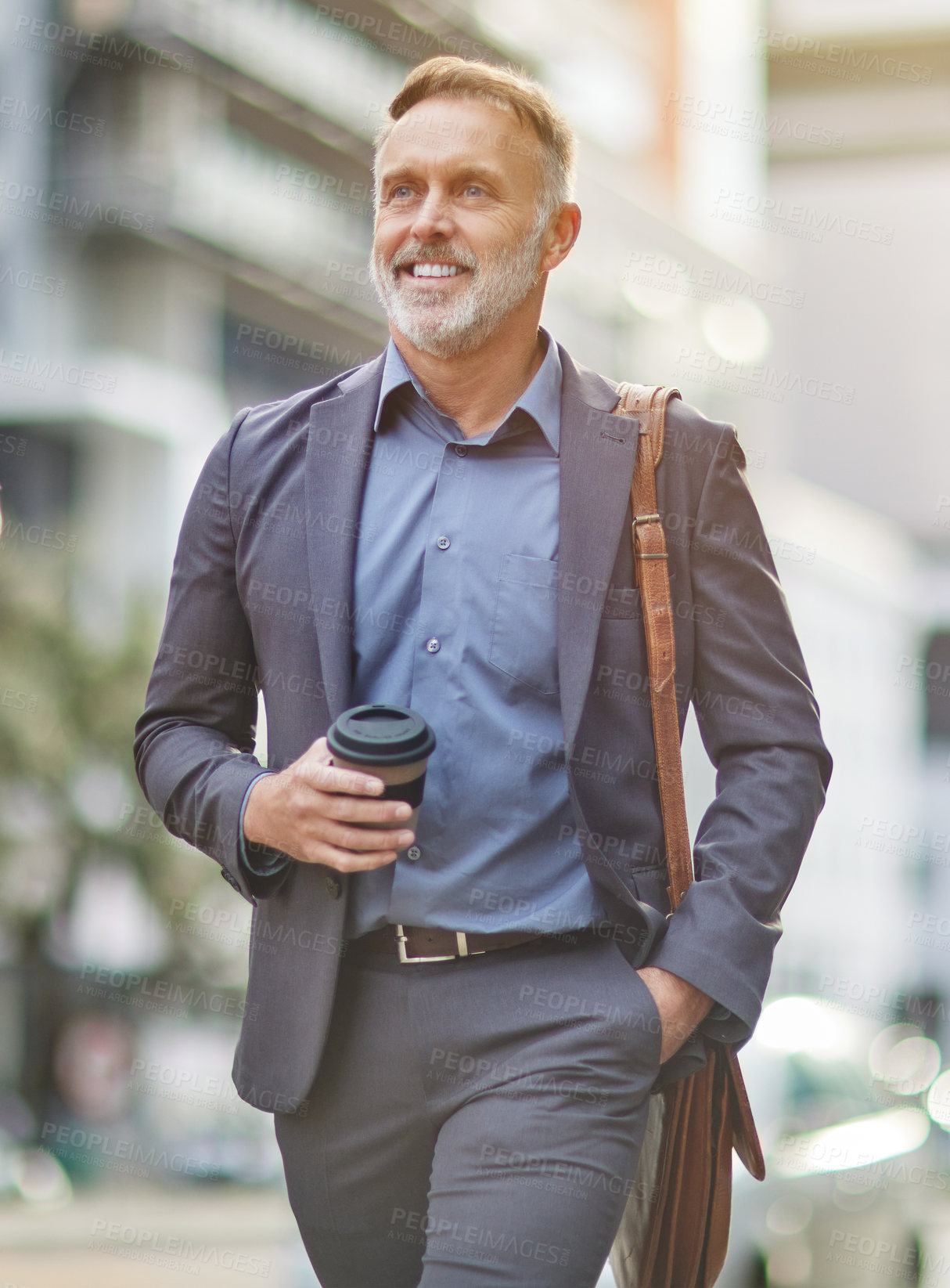 Buy stock photo Shot of a handsome mature businessman walking around town drinking coffee