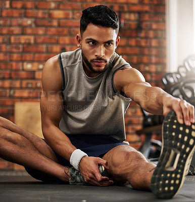 Buy stock photo Fitness, man and stretching legs for warm up at gym with motivation, training and focus mindset. Workout, commitment and athlete on floor with hand on foot leg for exercise goals at sports club