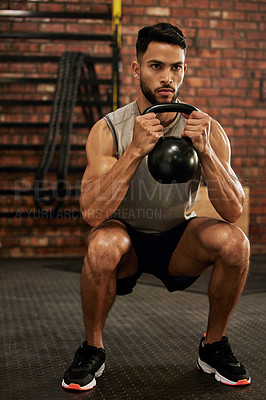Buy stock photo Bodybuilder, fitness and man with kettle bell in gym for exercise, strength training and workout. Sports, challenge and serious male person squat with weights for wellness, healthy body and muscles