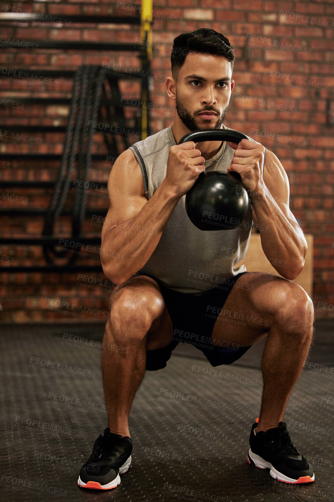 Buy stock photo Bodybuilder, fitness and man with kettle bell in gym for exercise, strength training and workout. Sports, challenge and serious male person squat with weights for wellness, healthy body and muscles