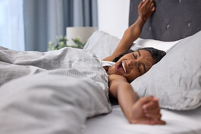 Buy stock photo Shot of a young woman yawning and stretching while lying in her bed