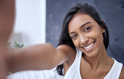 Buy stock photo Shot of a beautiful young woman taking a selfie at home