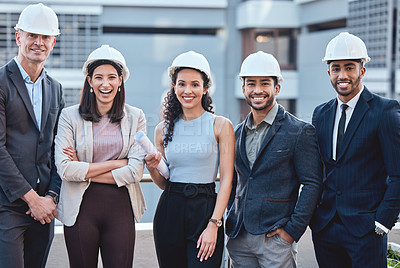 Buy stock photo Shot of a group of businesspeople wearing hardhats while standing outside