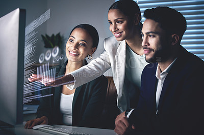 Buy stock photo Shot of a young group of businesspeople using a computer while working in the office at night