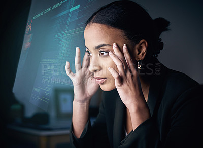 Buy stock photo Shot of an attractive young businesswoman sitting alone in the office at night and feeling stressed