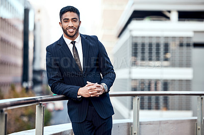 Buy stock photo Shot of a handsome young businessman standing alone outside