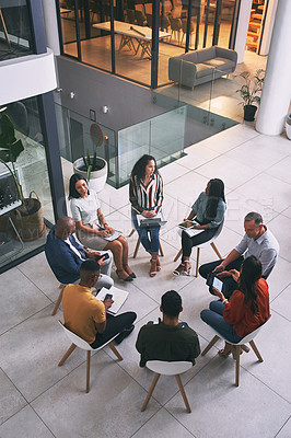 Buy stock photo Shot of a team of business people sitting together during a meeting