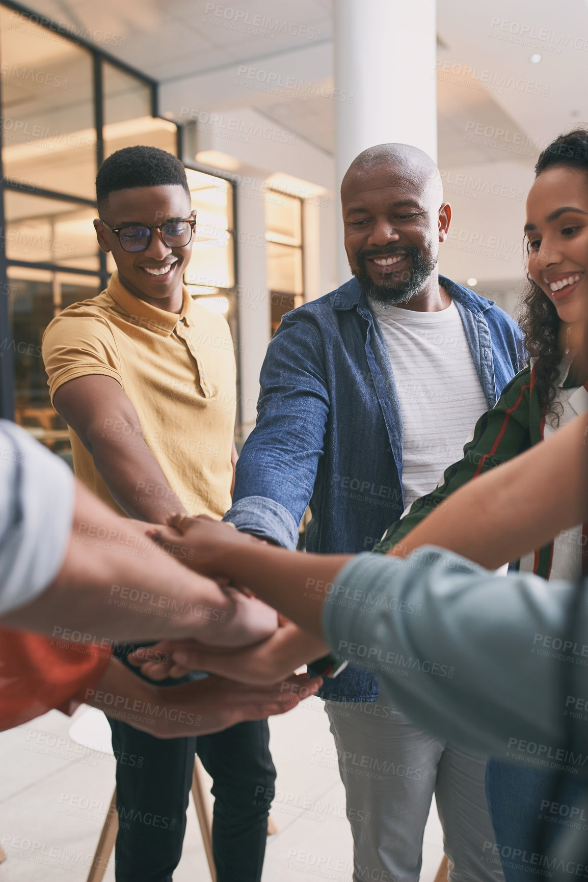 Buy stock photo Shot of a team of business people stacking their hands in motivation