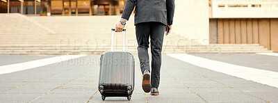 Buy stock photo Shot of a businessman walking around town with his luggage