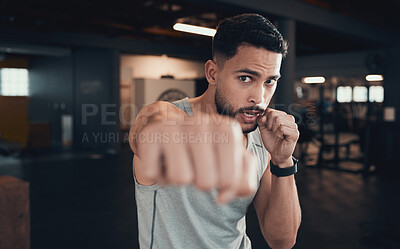 Buy stock photo Shot of a young man practicing his punching in the gym