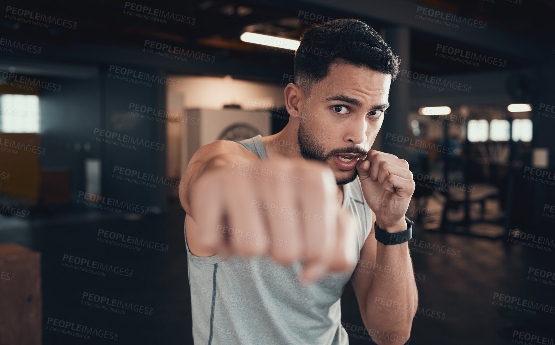 Buy stock photo Shot of a young man practicing his punching in the gym