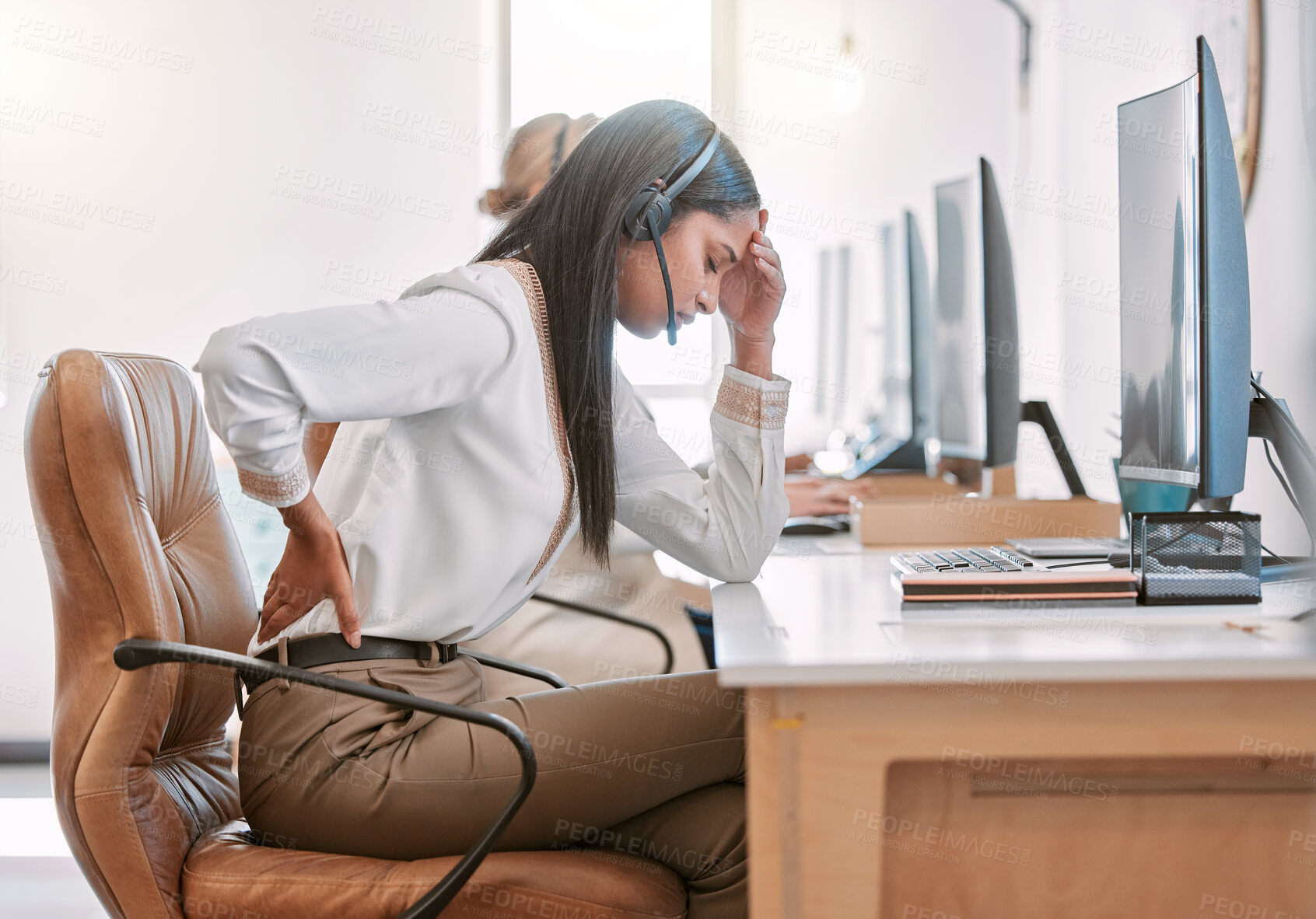 Buy stock photo Cropped shot of an attractive young female call center agent suffering with back pain while working on her computer in the office