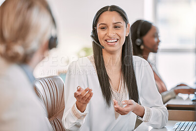 Buy stock photo Cropped shot of an attractive young call center agent wearing a headset and chatting to a colleague while working in the office