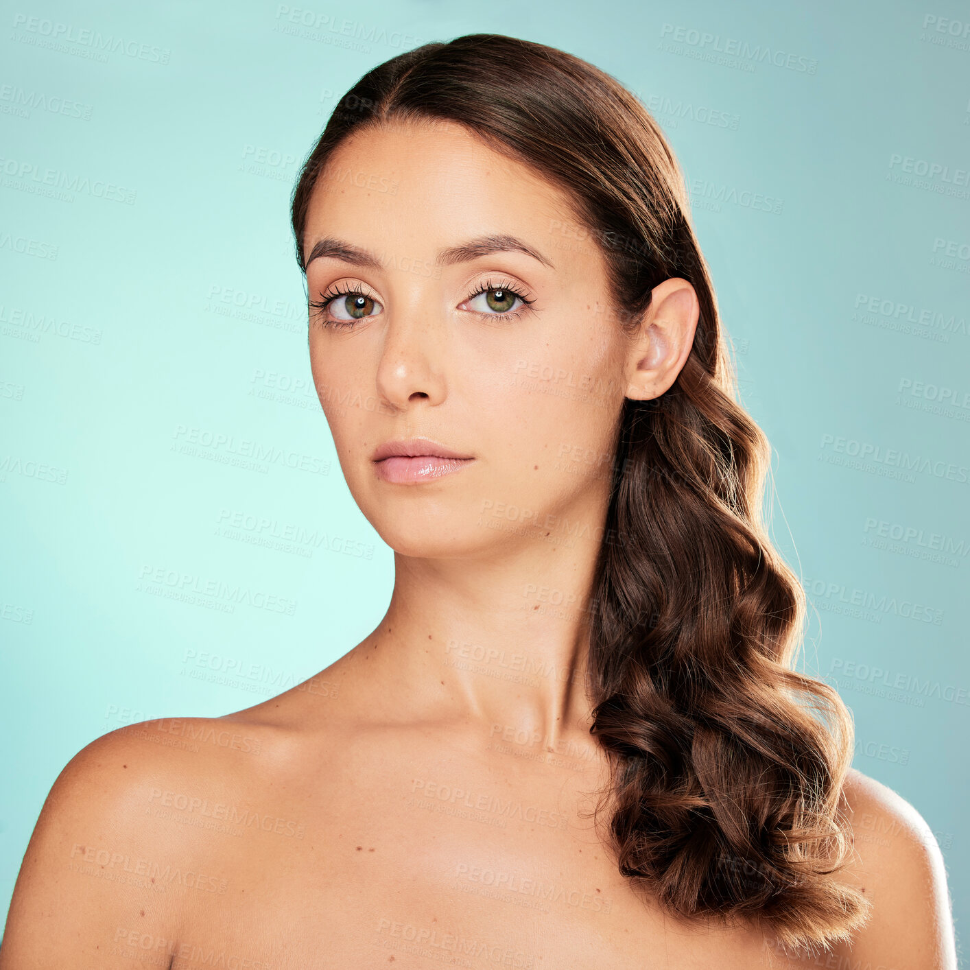 Buy stock photo Studio portrait of an attractive young woman posing against a blue background