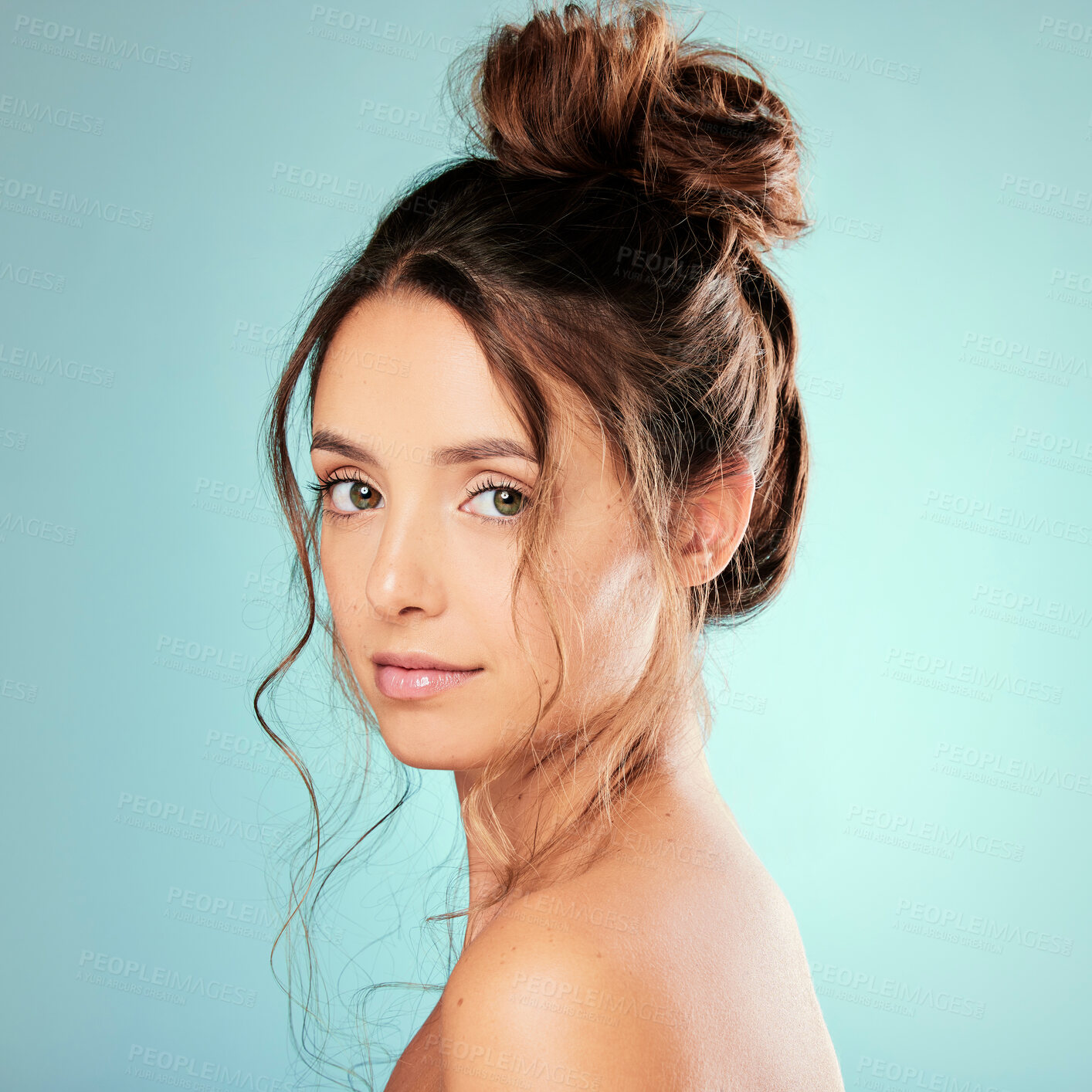 Buy stock photo Woman, portrait and hair care in studio with bun for texture, healthy growth or glow on blue background. Female person, trendy curly style and model with salon aesthetic, beauty and keratin results