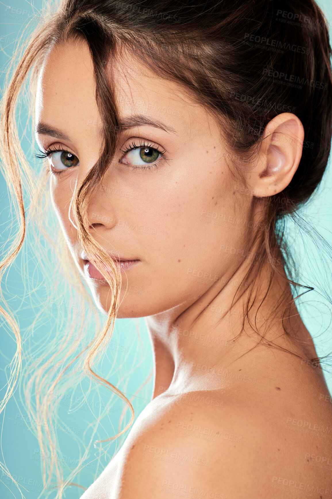 Buy stock photo Studio portrait of an attractive young woman posing against a blue background