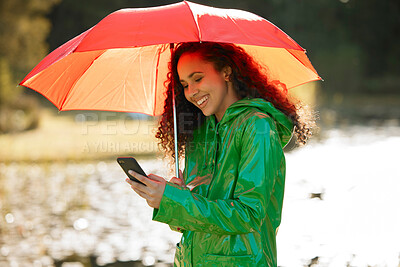 Buy stock photo Rain, phone or happy woman with umbrella in park for travel, adventure and journey in nature. Winter, storm and girl person in forest smartphone for online, map and taxi, request or chauffeur service